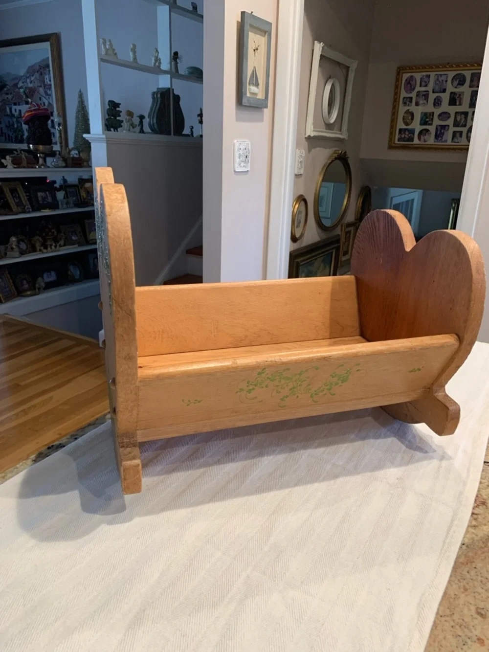 Vintage wooden doll cradle heart-shaped design painted with floral details.